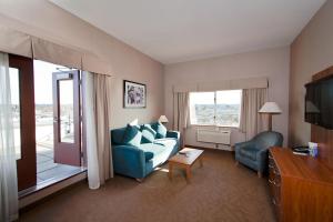 兰利海岸酒店&会议中心的客厅配有蓝色的沙发和电视