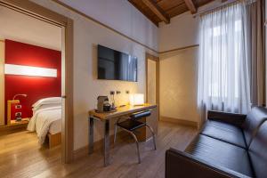 维罗纳阿曼多贝斯特韦斯特酒店的酒店客房配有书桌、床和沙发。
