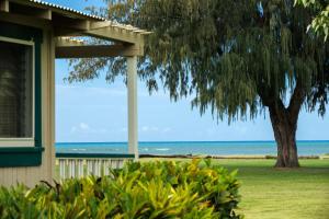 Waimea威美亚种植园别墅海岸酒店&度假村的一座有树和大海的房屋