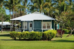 Waimea威美亚种植园别墅海岸酒店&度假村的棕榈树庭院中的蓝色小房子