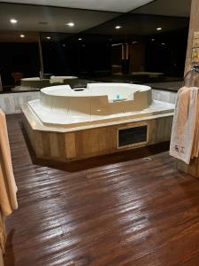 奥科约阿卡克Suites & Villas Real Hacienda的浴室铺有木地板,设有大浴缸。