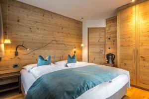 拉维拉普拉德多洛米蒂木屋公寓酒店的一间卧室设有一张带木墙的大床