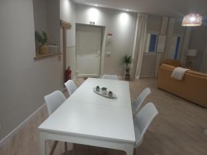 欧伦Casinha de Santo Amaro的客厅配有白色的桌椅