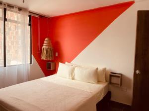 伊塔圭Chic Duplex Loft的卧室设有红色的墙壁和一张床