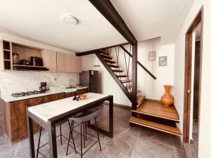 伊塔圭Chic Duplex Loft的厨房设有楼梯和带凳子的厨房