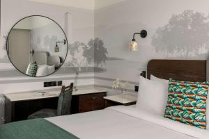 布兰察斯镇都柏林皇冠假日酒店布兰查的一间卧室配有一张带镜子的床和一张书桌