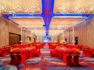 重庆重庆仙桃数据谷假日酒店的一个带红色桌椅的大型宴会厅