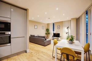 伦敦Modern 2BR London Flat Style and Comfort Combined的厨房以及带桌椅的起居室。