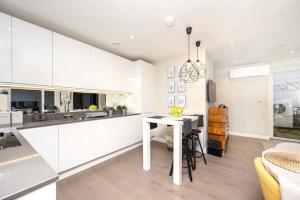 布罗姆利Stunning 2BR Apt Bromley Views Terrace的厨房配有白色橱柜和白色桌子