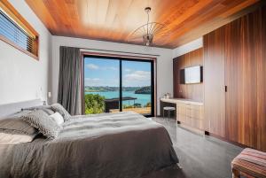旺阿雷Nook Bay House的一间卧室设有一张大床和一个大窗户