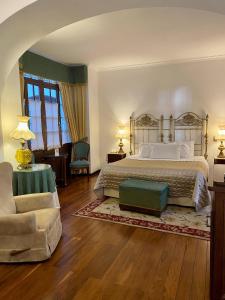 苏克雷圣玛丽亚皇家酒店的一间大卧室,配有一张床和一把椅子