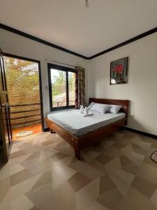 卢纳将军城SHELVES SIARGAO的一间卧室设有一张床和一个大窗户