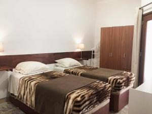 辛特拉Apartamento 2 Penedo的酒店客房设有两张床和橱柜。