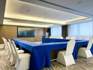 滨海新区天津极地海洋酒店的一间会议室,配有蓝色的桌子和白色的椅子