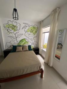 帕拉卡斯Hostel Killamoon Centro的卧室配有一张挂着花壁画的床。
