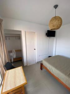 帕拉卡斯Hostel Killamoon Centro的卧室配有床、桌子和门