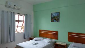 马拉巴PLAZA HOTEL MARABÁ的一间卧室设有两张床和窗户。