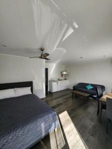 汉密尔顿Gardena Court Motel的一间卧室配有一张床、一张桌子和一张沙发