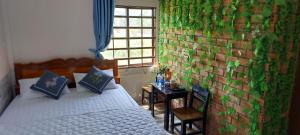 芹苴Cần Thơ Farmstay的一间卧室设有床铺,墙上覆盖着植物