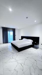 TarquiMantaSurf Hotel的一间设有一张大床和大理石地板的卧室