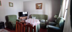 帕萨若ABUELA MARIA的客厅配有桌椅和电视。