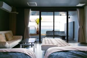 松山瀬戸内リゾートホテル的客房设有两张床、一张沙发和一个窗口。