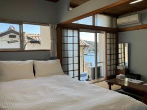 熊野市Oninosanpomichi的一间卧室设有一张床和一个美景窗户。