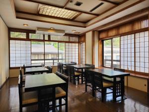 日光大和屋ホテルいろは的用餐室设有桌椅和窗户。