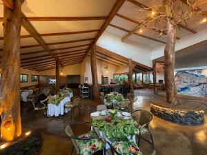 安加罗阿Hotel Hotu Matua的一间设有桌椅和树木的餐厅