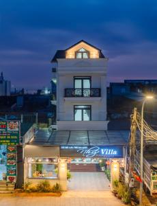 大叻Nhý Villa Đà Lạt Review的前面有标志的白色建筑