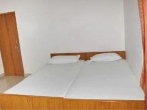 瓦拉纳西Hotel Teerth Guest House Inn Varanasi的客房内的一张带两个枕头的白色床