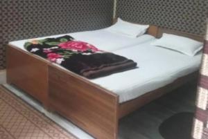 瓦拉纳西Hotel Teerth Guest House Inn Varanasi的一张带木床架的床,床上有毯子