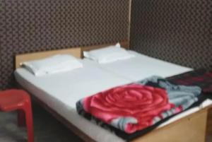 瓦拉纳西Hotel Teerth Guest House Inn Varanasi的一张白色的床,上面有红玫瑰毯