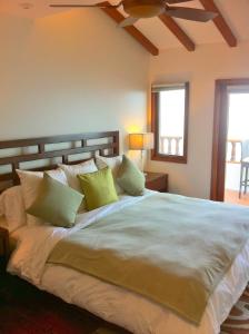阿瓦隆Amazing Luxury ocean front Hamilton Cove Villa welectric cart的一间卧室配有一张带绿色枕头的大床