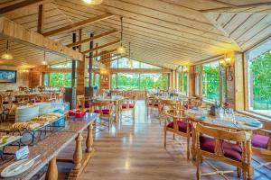 马拉里Storii By ITC Hotels Urvashis Retreat, Manali的餐厅铺有木地板,配有桌椅