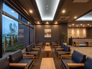 松茂町Hotel Route Inn Tokushima Airport -Matsushige Smartinter-的一间设有桌椅的等候室和一间酒吧