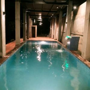 达博利The SKYi County Dapoli的夜间游泳池,设有喷泉