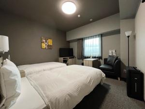松茂町Hotel Route Inn Tokushima Airport -Matsushige Smartinter-的酒店客房,配有两张床和椅子