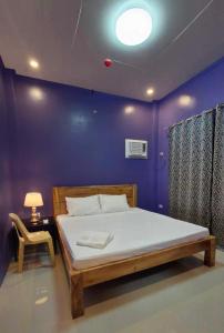 TubigonDrossgold Pension House的一间卧室配有一张紫色墙壁的床