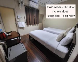 曼谷Achcha hotel - itsaraphap MRT station - Wat Arun的酒店客房配有两张床和一张书桌