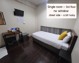 曼谷Achcha hotel - itsaraphap MRT station - Wat Arun的一间卧室配有一张带黄色枕头的床和一张书桌