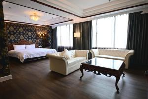 台中市T Hotel的酒店客房配有床、沙发和桌子。