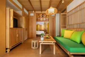 成都青城山六善酒店的客厅配有绿色沙发和桌子