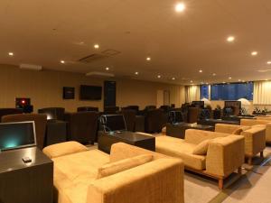 札幌The Centurion Sauna Rest & Stay Sapporo Male Only的一间配备有沙发、椅子和电视的会议室