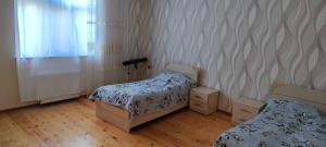 卡希Kirayə ev, Qax, Qaşqaçay guesthouse的一间卧室设有两张床、一个窗户和木地板。