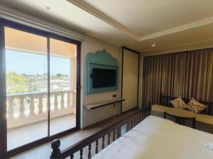 贾姆讷格尔Rajwadu The Village的酒店客房设有一张床和一个大窗户