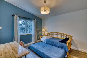 科迪亚克Lodge Style Living Spacious 5BR Reunion Getaway的一间卧室配有一张床、一张桌子和一个窗户。