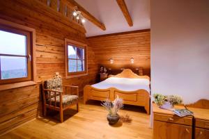 斯洛文尼亚格拉代茨Chalet Podgorje With Pool的卧室配有一张床铺,位于带木墙的房间内
