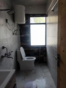 巴德里纳特Hotel Badrinath的一间带卫生间和窗户的小浴室