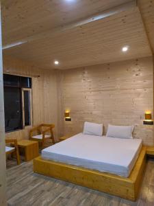 巴德里纳特Hotel Badrinath的木制客房内的一间卧室,配有一张床